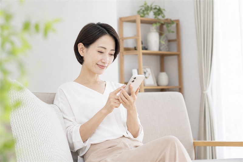 スマホで定期コースの解約手続きをする女性