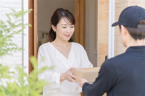自宅に届いた荷物を受け取る女性